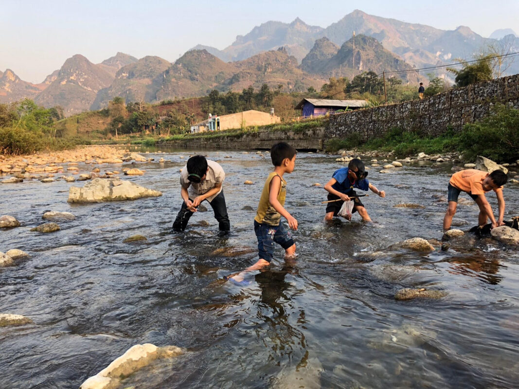 The children catch fish by hands in Du Gia village